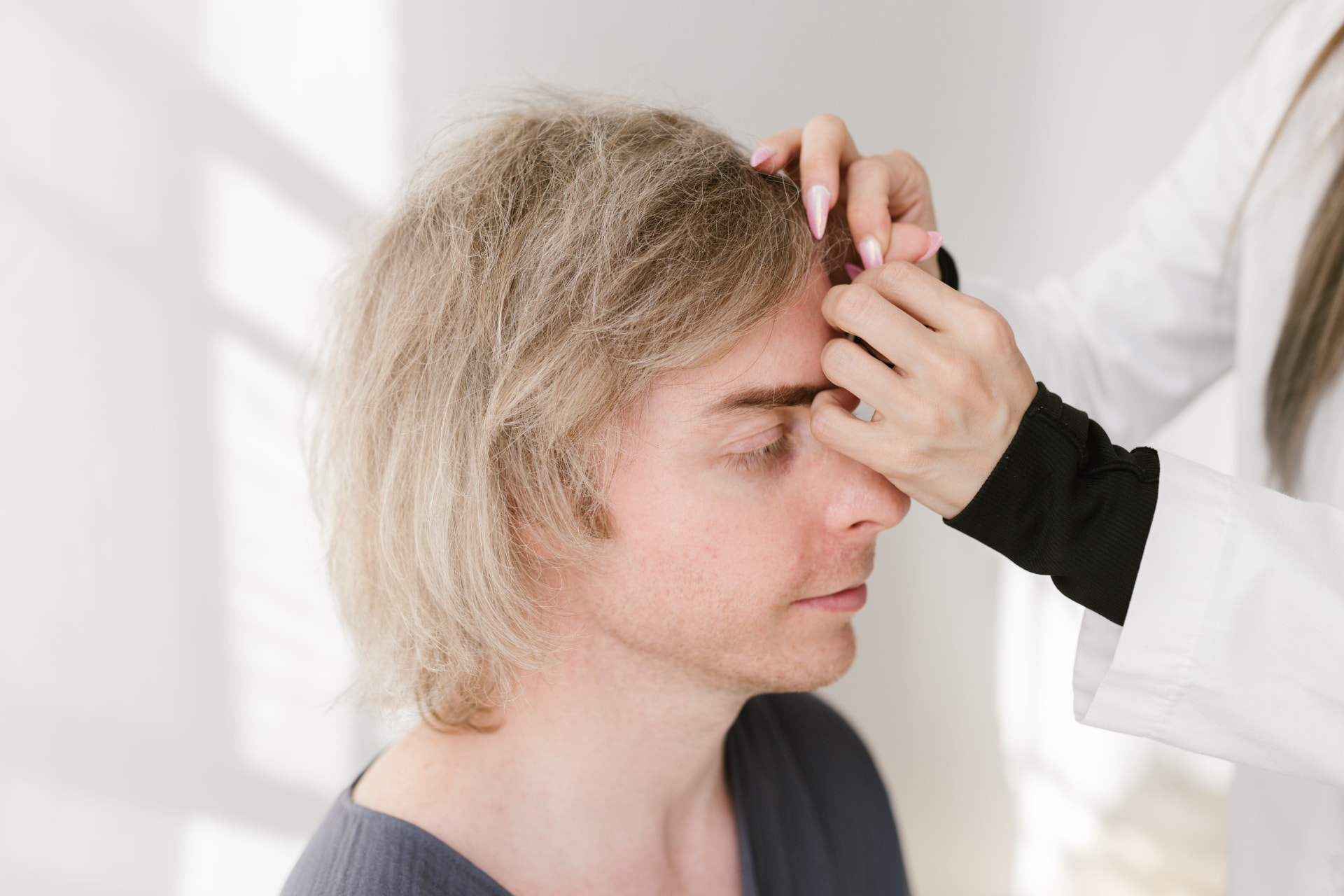 Clinician examining a patient's hair and scalp during an assessment